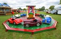 Children`s roundabout with classic Austin pedal cars Royalty Free Stock Photo