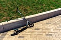 Children's scooter parked near the concrete curb. Outdoor Fun in the Summer