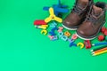 Children`s shoes for a boy made of leather with laces on a green background. Children`s toy, Pencils, colored letters and candie