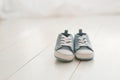 Children`s shoes, denim sneakers for baby on a light wooden background