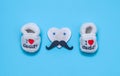 Children`s shoes and a heart with a mustache on blue.