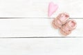 Children`s shoes pink color for baby on a white wooden backgroun Royalty Free Stock Photo