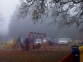 The children`s swings foggy morning in Harrow park.