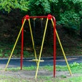 Children& x27;s swings hang empty an idle at a playground on a dull, overcast day Royalty Free Stock Photo