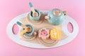 Children`s tea set, fake cake and biscuit, wooden kitchenware. Cute kids toys to play in the kitchen, blue cups with teapot.