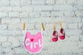 Children`s toddler pink saliva and red shoes on a rope against a white brick wall. Royalty Free Stock Photo