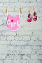 Children`s toddler pink saliva and red shoes on a rope against a white brick wall. Royalty Free Stock Photo