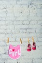 Children`s toddler pink saliva and red shoes on a rope against a white brick wall. Royalty Free Stock Photo