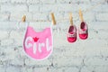 Children`s toddler pink saliva and red shoes on a rope against a white brick wall. Royalty Free Stock Photo