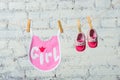 Children`s toddler pink saliva and red shoes on a rope against a white brick wall. Royalty Free Stock Photo
