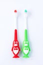 Children's toothbrushes in a form of red and green penguins on a white background isolated Royalty Free Stock Photo