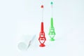 Children& x27;s toothbrushes in a form of red and green penguins on a white background 