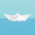 A children`s toy boat made of paper afloat, leaving circles of ripples on the water. On a blue background.