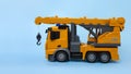 children`s toy - car crane on blue background side view Royalty Free Stock Photo