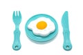 Children`s toy plastic tableware: plate with fried eggs, fork and knife. Serving set Royalty Free Stock Photo