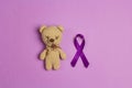 Children`s toy with a Purple epilepsy awareness ribbon on a purple background. World epilepsy day