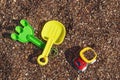 Children`s toy truck with gravel or sand. Yellow scoop and green rake. Concept of transportation of goods and building