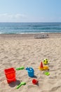 children's toys on the beach sand against turquoise sea