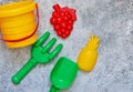 Children`s toys: bucket, shovel, rake on a stone background. Toy Royalty Free Stock Photo