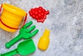 Children`s toys: bucket, shovel, rake on a stone background. Royalty Free Stock Photo