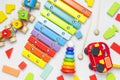 Children`s toys made of natural wood on white background. Multi-colored pyramid, train, constructor, xylophone in rainbow colors. Royalty Free Stock Photo