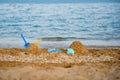 Children`s toys on a sandy beach, blue sea in the background