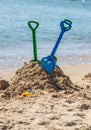 Children's toys on a sandy beach, blue sky and the sea in the background Royalty Free Stock Photo