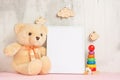 Children`s toys, a teddy bear and a frame on a light wall background, for design, layout. Baby shower