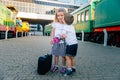 Children`s travel, travel with a child. The child goes to sea, on vacation. A boy meets a girl at the station with flowers and