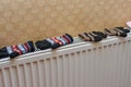 Children`s winter woolen mittens are dried on the heater after playing in the snow Royalty Free Stock Photo