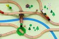 Children`s wooden railway with a steam locomotive and magnet cars, top view. A painted landscape with a river and trees, a toy