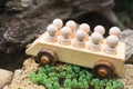 Children`s wooden toys. Children wooden car with passengers outdoors. Natural wood construction set