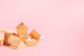 Children`s wooden toys on a pink background concept zero west. Small houses the designer from developing color cubes