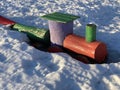 children's wooden train bench sticks out from under the snow Royalty Free Stock Photo