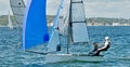 Children sailing racing small sailboat with a blue spinaker on a coastal lake. Commercial use photo Royalty Free Stock Photo