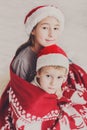 Children in santa hats near christmas tree, wait for holidays Royalty Free Stock Photo