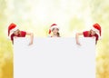 Children in santa helper hats with blank board Royalty Free Stock Photo