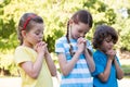 Children saying their prayers in park