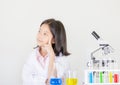 Children science concept, Happy little girl is sitting at the table and thinking at the laboratory with white background Royalty Free Stock Photo