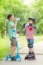 Children with scooter and rollers drink water