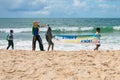 Children from a scout group cleaning Itapua beach and holding a sign promoting the preservation of the environment