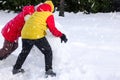 Children sculpt a snowman in winter