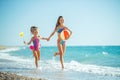 Children at sea play merrily. Two sisters run, jump on the beach in summer. Royalty Free Stock Photo