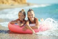 Children at sea play merrily. Two sisters run, jump on the beach in summer. Royalty Free Stock Photo
