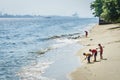 Children searching for seashell beside the beach near Sembawang Park, Singapore.