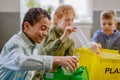 Children separating rubish in to three bins. Royalty Free Stock Photo