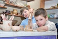 Children shaping clay in pottery studio