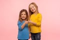 Children showing like, approval sign. Two adorable happy little girls gesturing thumbs up together and smiling to camera Royalty Free Stock Photo