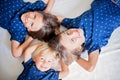 Children, sibling brothers, lying on the floor on white blanket, looking up at the camera, smiling