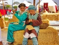 Children sit on the hay and weave baskets out of straw